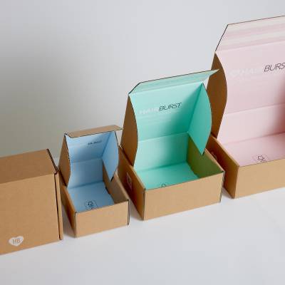 Row of Hair Burst eCommerce packaging boxes of different sizes open with differet colours inside